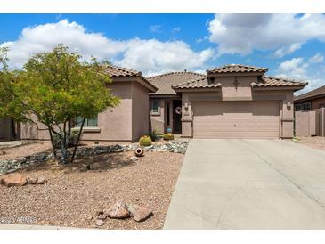Charming single-story home showcasing a low-maintenance desert landscape and two-car garage in a sunny neighborhood at 7554 E Globemallow Ln, Gold Canyon, AZ 85118