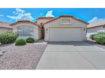 Charming single-story home with stucco exterior, red tile roof and low-maintenance desert landscaping at 9837 W Tonopah Dr, Peoria, AZ 85382