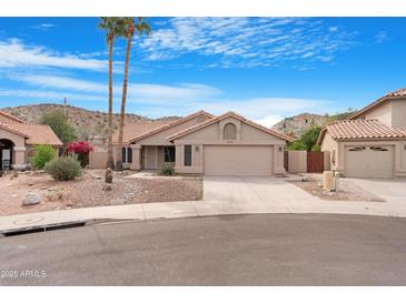 Charming single-story home featuring a desert landscape, tile roof, and a two-car garage at 15437 S 23Rd Pl, Phoenix, AZ 85048