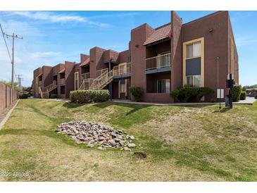 Attractive condominium building with a red brick exterior, walkways and lovely landscaped grounds at 16602 N 25Th St # 112, Phoenix, AZ 85032