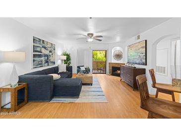 Bright living room with wood floors, a fireplace, and contemporary decor, flowing into an open-concept layout at 5104 N 32Nd St # 311, Phoenix, AZ 85018
