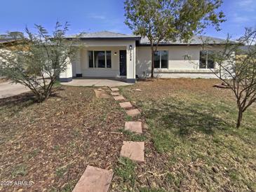 Charming single-story home with a stepping stone walkway and well-manicured lawn at 7334 W Comet Ave, Peoria, AZ 85345