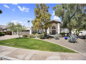 Charming home with beautifully landscaped front yard, mature trees and a welcoming facade at 9760 E San Salvador Dr, Scottsdale, AZ 85258