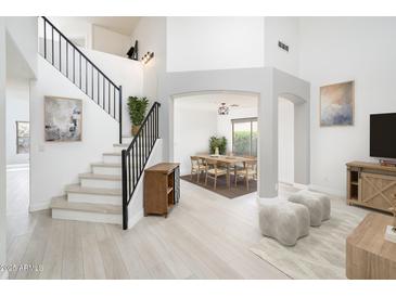 Inviting foyer showcasing a staircase with metal railings, an art niche, and easy access to the dining room at 10219 E Le Marche Dr, Scottsdale, AZ 85255
