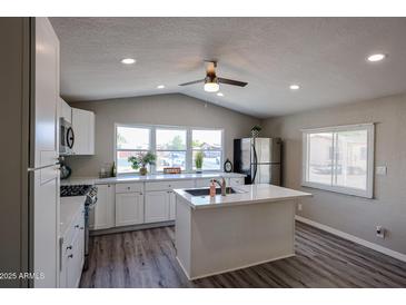 Bright kitchen featuring white cabinets, stainless steel appliances, kitchen island, and lots of natural light at 11275 N 99Th Ave # 170, Peoria, AZ 85345