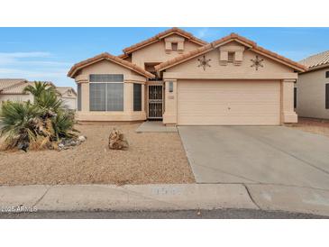 Charming single-story home featuring a well-maintained yard and a two-car garage at 11540 W Sonoran Ct, Surprise, AZ 85378