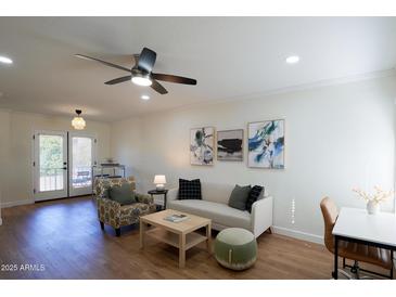 Bright living room featuring a ceiling fan, modern furnishings and three unique pieces of wall art at 1302 E Maryland Ave # 15, Phoenix, AZ 85014