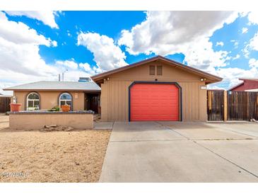 Charming single-story home with a bright red garage door and low-maintenance desert landscaping at 1437 W Renee Dr, Phoenix, AZ 85027
