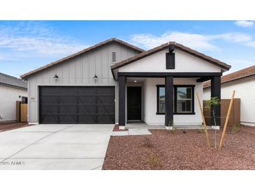 Charming single-story home with a black garage door and desert landscaping at 23403 W Albeniz Pl, Buckeye, AZ 85326