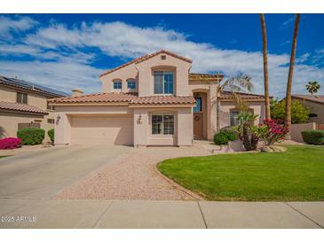 Charming two-story home featuring a well-manicured lawn, mature trees, and a tile roof at 7170 W Crystal Rd, Glendale, AZ 85308