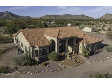 Expansive view of a desert home with red tile roof, desert landscaping, and views of the surrounding mountains at 9690 W Martin Rd, Casa Grande, AZ 85194