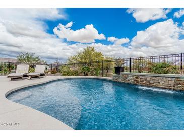 Luxurious pool featuring a waterfall feature, landscaping and inviting lounge chairs at 19633 N 264Th Ave, Buckeye, AZ 85396