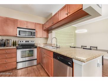 Efficient kitchen with stainless steel appliances, granite countertops, and wooden cabinets at 5345 E Van Buren St # 258, Phoenix, AZ 85008