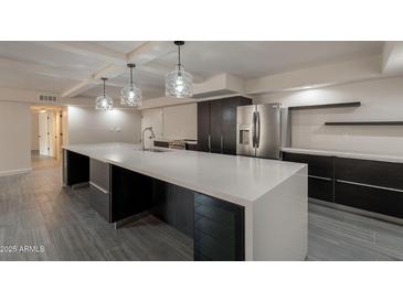 Spacious kitchen features a large island, stainless appliances, and modern lighting and gray tile flooring at 7960 E Camelback Rd # 110, Scottsdale, AZ 85251
