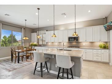 Modern kitchen with a spacious island, stainless steel appliances, and pendant lighting at 11609 W Andrew Ln, Peoria, AZ 85383
