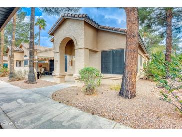 Charming single-story home featuring a stucco exterior, tiled roof, and an inviting arched entryway at 14300 W Bell Rd # 245, Surprise, AZ 85374