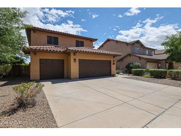 Charming two-story home featuring a three-car garage, tile roof, and well-maintained landscaping at 14733 N 159Th Dr, Surprise, AZ 85379