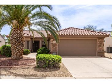Charming single-story home with a well-manicured yard, stone accents, and a tile roof at 16331 W Tierra Way, Surprise, AZ 85374