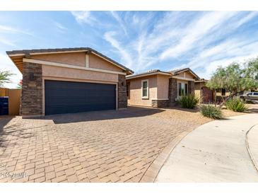View of the exterior of a single-story home with a brick driveway and landscaping at 22434 S 226Th Pl, Queen Creek, AZ 85142
