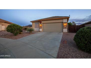 Home exterior with stone accents, desert landscaping, concrete driveway, and a two car garage at 24721 W Dove Butte --, Buckeye, AZ 85326