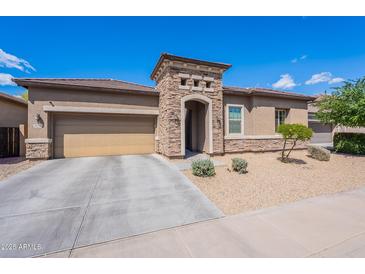 Charming single-story home featuring a stone facade, desert landscaping, and a two-car garage at 3028 W T Ryan Ln, Phoenix, AZ 85041