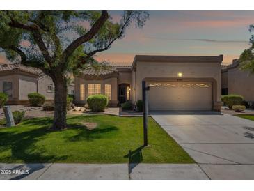 Inviting single-story home featuring a well-manicured lawn and a convenient two-car garage at 8405 W Utopia Rd, Peoria, AZ 85382