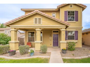 Inviting home exterior with a covered porch, tidy landscaping, and a cozy chair to relax on the porch at 2873 S Arroyo Ln, Gilbert, AZ 85295