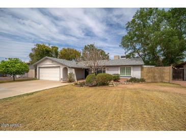 Charming single-story home features a well-manicured lawn and attached two-car garage at 1014 W Hononegh Dr, Phoenix, AZ 85027
