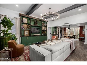 Spacious living room featuring custom green built-ins and a decorative chandelier at 1025 E Northern Ave, Phoenix, AZ 85020