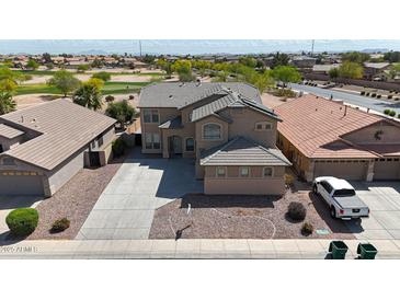 Two-story home features desert landscaping, an attached garage, and a concrete driveway on a sunny day at 21549 N Backus Dr, Maricopa, AZ 85138