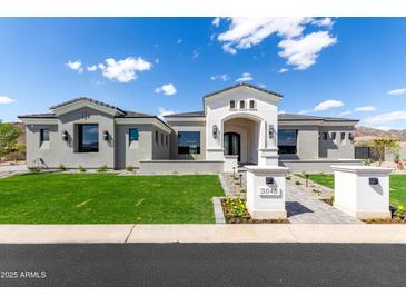 Stunning single-story home featuring lush green lawn, elegant stone walkway and a three-car garage at 3046 W Redwood Ln, Phoenix, AZ 85045