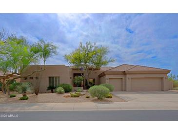 Attractive one-story home featuring desert landscaping, a tile roof, and an attached two-car garage at 33242 N 68Th Pl, Scottsdale, AZ 85266