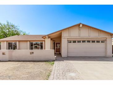 Inviting single-story home with a neutral color palette, a two car garage, and a well kept walkway at 3941 W Desert Hills Dr, Phoenix, AZ 85029