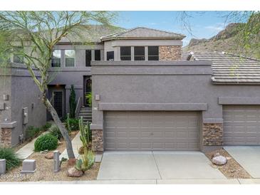 Inviting home with a two-car garage, desert landscaping, and a mix of stone and stucco exterior at 5118 S Morning Sky Trl, Gold Canyon, AZ 85118