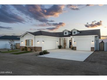 Stunning white home featuring a three car garage, stone accents, and beautiful curb appeal at 6244 S Flora Ln, Gold Canyon, AZ 85118