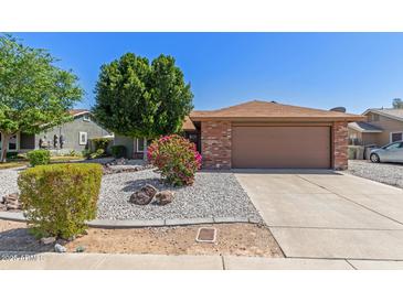 Charming single-story home featuring a low-maintenance desert landscape and a two-car garage at 6413 W Monte Cristo Ave, Glendale, AZ 85306