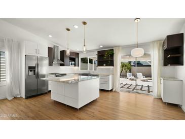 Modern kitchen with stainless steel appliances, island, and sliding door to the backyard at 6833 E Grandview Dr, Scottsdale, AZ 85254