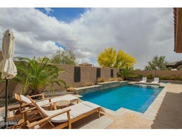 Inviting private pool with lounge chairs, landscaping, and blue water at 12031 S 184Th Ave, Goodyear, AZ 85338