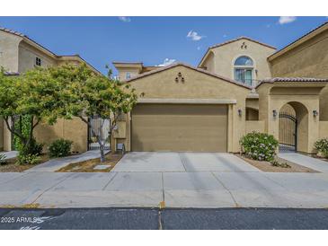 Beige two-car garage featuring desert landscaping and wrought iron pedestrian access at 1367 S Country Club Dr # 1189, Mesa, AZ 85210