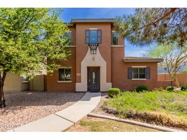 Charming two-story home featuring a desert landscape, neutral-tone paint, and inviting entryway at 14239 W Port Royale Ln, Surprise, AZ 85379