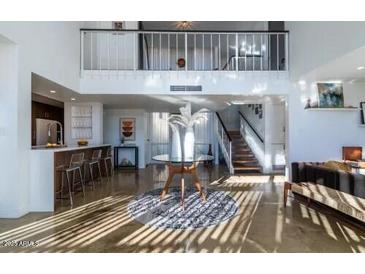 Bright, open living room with high ceilings, statement rug, and unique architectural details at 1621 E Maryland Ave, Phoenix, AZ 85016