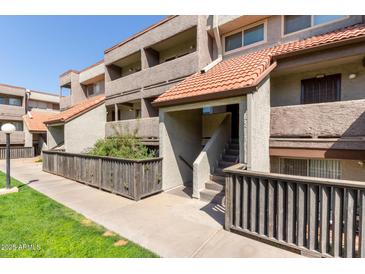 Inviting condo exterior with well-maintained landscaping, warm desert tones, and a classic tile roof at 1645 W Baseline W Rd # 2032, Mesa, AZ 85202