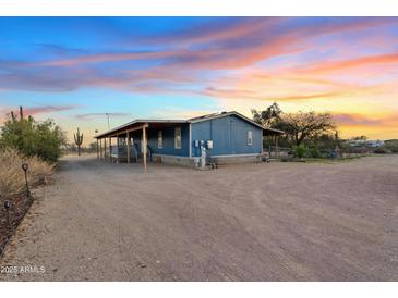 Charming single-story home with a covered porch and desert landscaping at 16643 W Quail Run Rd, Surprise, AZ 85378