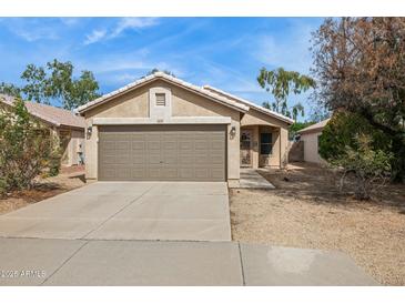 Charming single-story home featuring a two-car garage and low-maintenance desert landscaping at 16729 N 157Th Ave, Surprise, AZ 85374