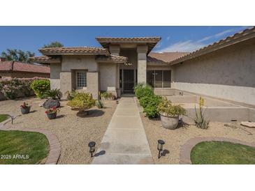 Inviting home entrance with desert landscaping and a walkway leading to the front door at 17790 N 66Th Ln, Glendale, AZ 85308