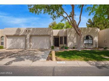 Charming single-story home featuring a well-maintained lawn and two-car garage at 18725 N 92Nd Dr, Peoria, AZ 85382