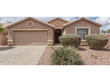 Charming single-story home with a two-car garage and desert landscaping at 22300 N Kingston Dr, Maricopa, AZ 85138