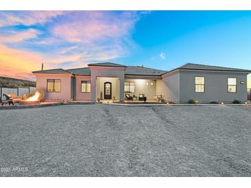 Beautiful exterior of this home featuring desert landscaping, a fire pit and charming front porch at 28204 N Royce Rd, Queen Creek, AZ 85144