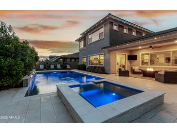 A backyard oasis with a pool, hot tub, and inviting patio area perfect for evening gatherings under the stars at 3749 E Sagebrush St, Gilbert, AZ 85296