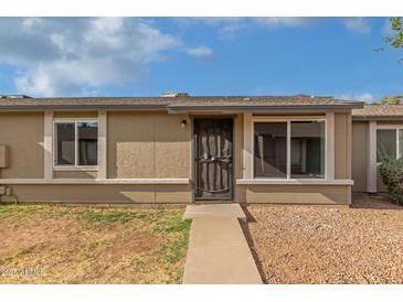 Home exterior with a desert landscape, pathway to a secure front door, and large windows at 6711 W Osborn Rd # 68, Phoenix, AZ 85033